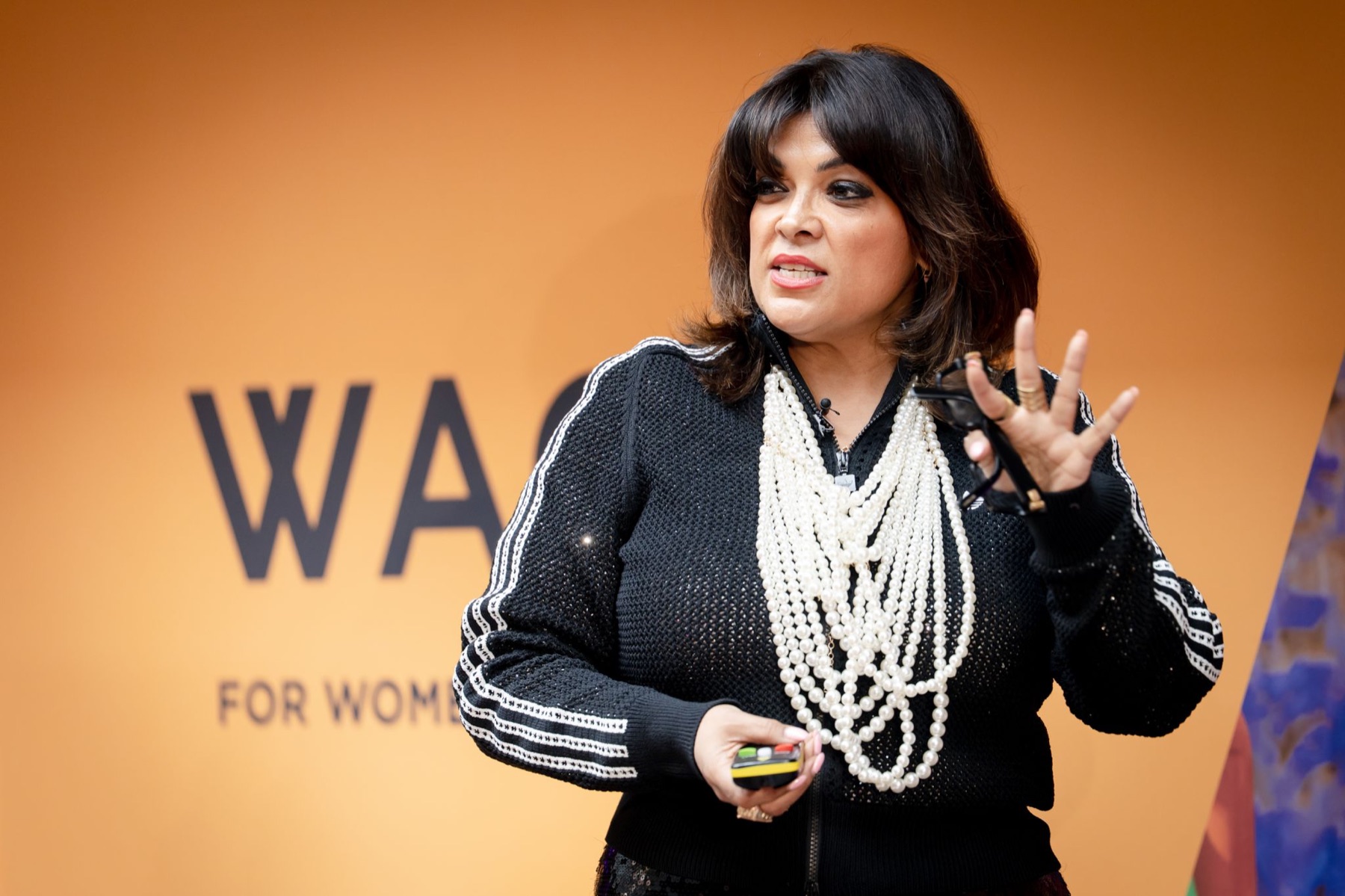 Nishma speaking in front of a WACL backdrop